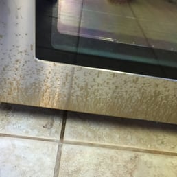 Brand new stainless stove after David cleaned our tile floor. The treatment and lack of cleaning his mess up has caused pitting/staining.