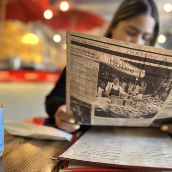 Thai Market - a woman reading a newspaper - Thai Near Me - New York, New York Thai Market - a woman reading a newspaper - Thai Near Me - New York, New York