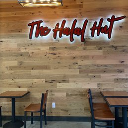 tables and chairs in front of a wood paneled wall