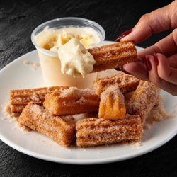 Fuego Cravings - Golden, filled bite-sized churros coated in cinnamon sugar, served with your choice of dip.