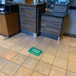 a starbucks sign on the floor of a coffee shop