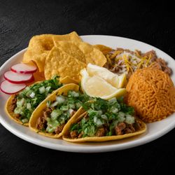 Fuego Cravings - Street Taco Plate loaded with fresh cilantro, onions & guac sauce served with rice, beans & crispy chips