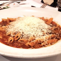 Penne with Bolognese meat sauce topped with shredded parmesan cheese Penne with Bolognese meat sauce topped with shredded parmesan cheese