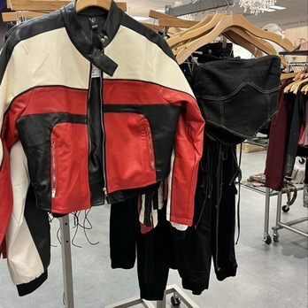 Windsor - A leather jacket with color blocks of black, white, and red is displayed on a hanger in a retail store, alongside other clothing items. - Accessories Near Me - Beachwood, Ohio