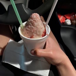 a hand holding a cup of ice cream