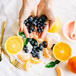 Body Mind Belly - ID: hands offering blueberries Photo by Brit Alamillo