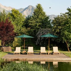 Sonnenalp Resort - Liegestühle in idyllischer Atmosphäre am Bergsee, im Hintergrund das Allgäuer Bergpanorama.