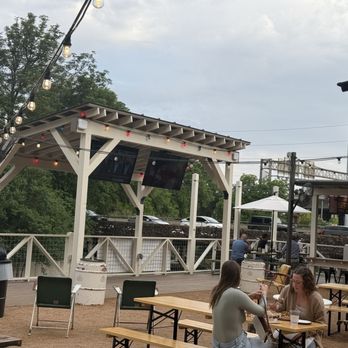 Otto’s Ice House - Outdoor seating area, TVs, & bar overlooking the riverwalk. - Bars Near Me - San Antonio, Texas