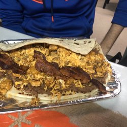 Silva's Groceries Y Cocina - Don Silva's breakfast taco: beans, chorizo, bacon, cheese. For reference look at the skinny arm compared to the giant taco.