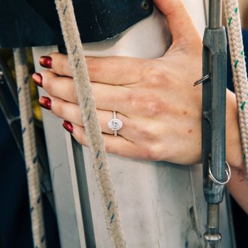 Razny Jewelers - Custom ring with Pam's help. Diamond band with a halo of diamonds surrounding the oval center stone. Picture taken on a sailboat. - Jewelry Near Me - Addison, Illinois