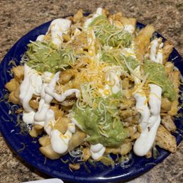 a plate of nachos and a bowl of guacamole a plate of nachos and a bowl of guacamole