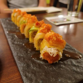 Tanoshi - a close up of a sushi roll on a black plate - Sushi Bars Near Me - Chicago, Illinois