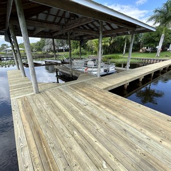 Florida Central Unlimited - a dock with a boat docked - Decks & Railing Near Me Florida Central Unlimited - a dock with a boat docked - Decks & Railing Near Me