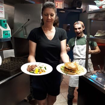 Dockside on the Cove - a woman holding two plates of food - Desserts Near Me - Tilbury, Ontario