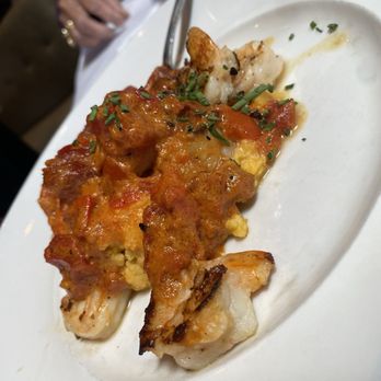 Seasons 52 - Wood-Grilled Shrimp And Grits - A dish featuring wood-grilled shrimp topped with tomato-based sauce and garnished with chopped herbs, served on a white plate. - New American Near Me - Albuquerque, New Mexico