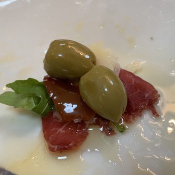 Lucano - Carpaccio, arugula, olives, EVOO, and a twist of salt. - Italian Near Me - Kirkwall, ORK