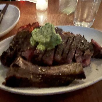 Rolo's - Dry aged ribeye steak grilled over a wood fire, 27 oz ($4.25/oz). Green garlic butter. - Sandwiches Near Me - Ridgewood, New York Rolo's - Dry aged ribeye steak grilled over a wood fire, 27 oz ($4.25/oz). Green garlic butter. - Sandwiches Near Me - Ridgewood, New York