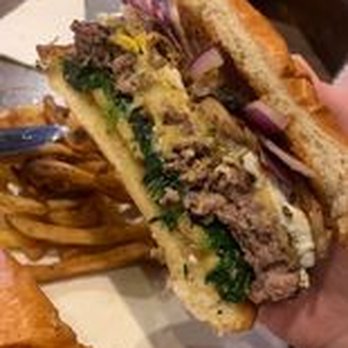 Liz’s Tavern - a hand holding a sandwich - Bars Near Me - Bellingham, Massachusetts