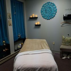 Sea Breeze Massage - Massage bed in the room. LED candles surround the bed with calming music and scents being diffused during the session.