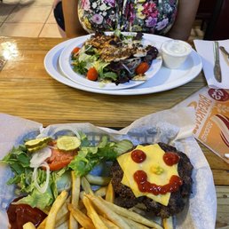 a woman sitting at a table with a plate of food a woman sitting at a table with a plate of food