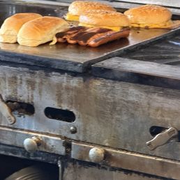 Some burgers and dogs on the griddle Some burgers and dogs on the griddle