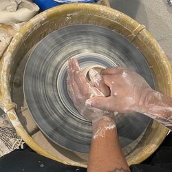 Student throwing pottery on the wheel