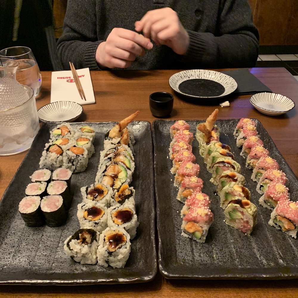 Amai Sushi - a man sitting at a table with two trays of sushi - Poke Near Me - Brookfield, Connecticut