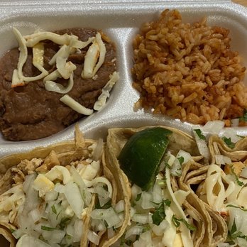 Taco Moro - Chicken Taco Dinner - A foam takeout container holds beef with cheese, seasoned rice, and three tacos topped with cheese, onions, and herbs, with a lime wedge. - Mexican Near Me - Chicago, Illinois