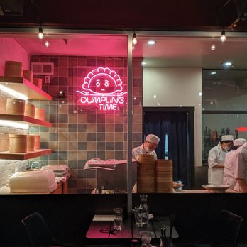 Dumpling Time - A window into the dumpling making process, illuminated by a bright, pink, neon sign in the shape of a smiling dumpling. - Dim Sum Near Me - San Francisco, California Dumpling Time - A window into the dumpling making process, illuminated by a bright, pink, neon sign in the shape of a smiling dumpling. - Dim Sum Near Me - San Francisco, California