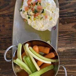Tzatziki dip topped with tiny chunks of cucumber, pungent tomatoes, and olive oil served with fresh carrots and celery Tzatziki dip topped with tiny chunks of cucumber, pungent tomatoes, and olive oil served with fresh carrots and celery