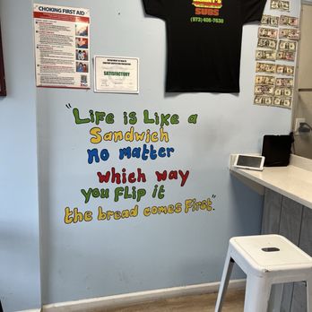 Sammy’s Subs - Great attitude - The wall features a colorful quote about life and sandwiches, along with a Sammy's Subs T-shirt and dollar bills displayed on the side. - Sandwiches Near Me - Wayne, New Jersey