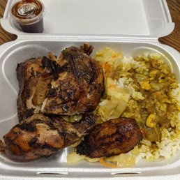 Jerk chicken with white rice. Curry gravy on the rice. Congress with cabbage and plantain.