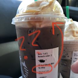 a person holding a cup of iced coffee a person holding a cup of iced coffee