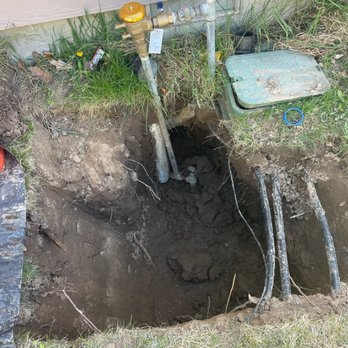 Beacon Plumbing - An in-progress photo the plumber sent me that shows the hole they dug. The sprinkler manifold box was exposed with an excavator. - Plumbing Near Me - Boise, Idaho
