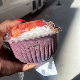 a hand holding a container of fruit a hand holding a container of fruit