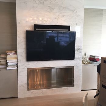 Barocco Marble & Granite - Calacatta gold marble wrapped feature wall with bioethanol fireplace and flat screen TV. - Fireplace Services Near Me - Spring Valley, New York Barocco Marble & Granite - Calacatta gold marble wrapped feature wall with bioethanol fireplace and flat screen TV. - Fireplace Services Near Me - Spring Valley, New York
