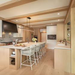 Northside Design Collective - Custom Kitchen with white oak cabinetry and beams, steel hood, outdoor rated counter stools and a slab backsplash.