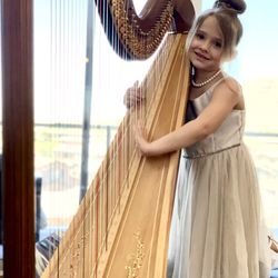 Kristie’s Music Studio - An excited student at her first harp lesson!