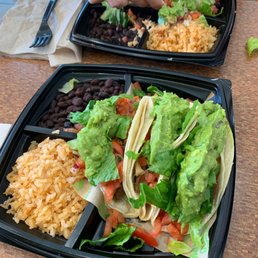 two plates of tacos and rice