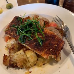 Blackened salmon entree with potatoes and tomatoes. Blackened salmon entree with potatoes and tomatoes.