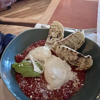 Ostra - EGGS A LA PROVENCAL  Two Poached Eggs, Tomato Sauce, Sofrito, Avocado, Cotija, Grilled Bread - New American Near Me - San Antonio, Texas