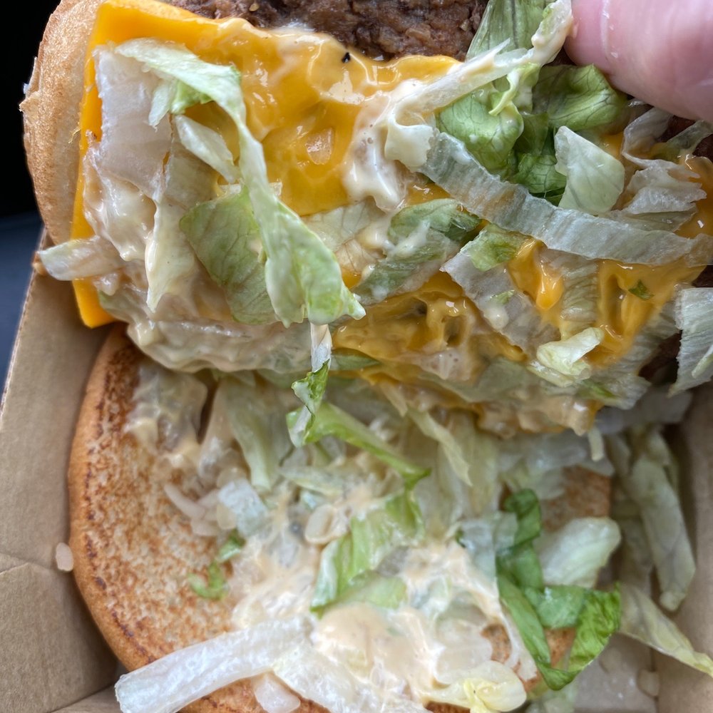 McDonald's - a hand holding a cheeseburger - Fast Food Near Me - Peru, Indiana McDonald's - a hand holding a cheeseburger - Fast Food Near Me - Peru, Indiana