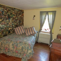Pebble Hall Country Lodging - Equestrian Room has a full-sized bed, a wall mural of horses, and morning sun.