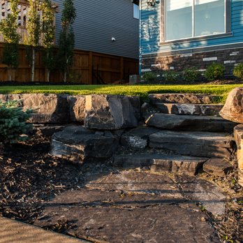 Infinity Gardens - a front yard with stone steps leading up to a house - Landscaping Near Me Infinity Gardens - a front yard with stone steps leading up to a house - Landscaping Near Me