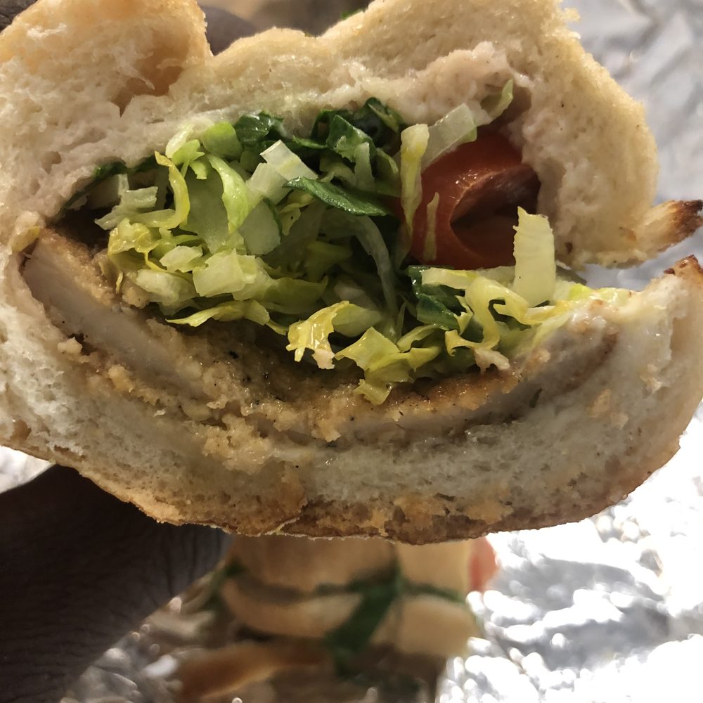 Ti Amo Pizza - a hand holding a sandwich - Pizza Near Me - Staten Island, New York