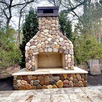 DC EXCO - Outdoor Fireplace finished in beautiful veneer with Travertine Hearth and a Custom Stone Cap to finish it off - Excavation Services Near Me - Mansfield, Massachusetts
