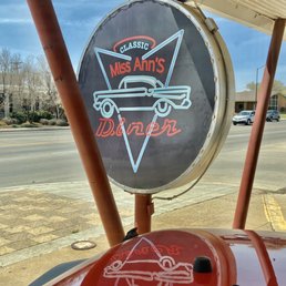 a red car parked in front of a gas station