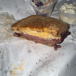 Half of the sandwich was already eaten! Coleslaw & potato salad in the back Half of the sandwich was already eaten! Coleslaw & potato salad in the back