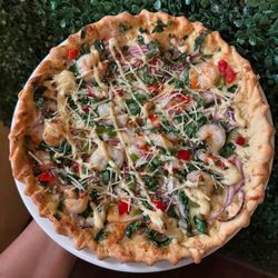 Table 59 - Creamy Cajun sauce Pizza topped with shrimp, onions, bell peppers, and spinach drizzled in Cajun sauce.