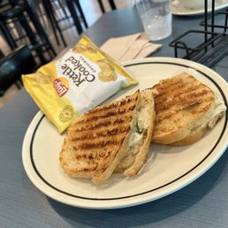Pesto cheese sandwich with chips.